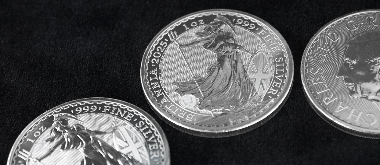 Monedas de plata Britannia de 1 onza de 2025, sobre un tapete oscuro
