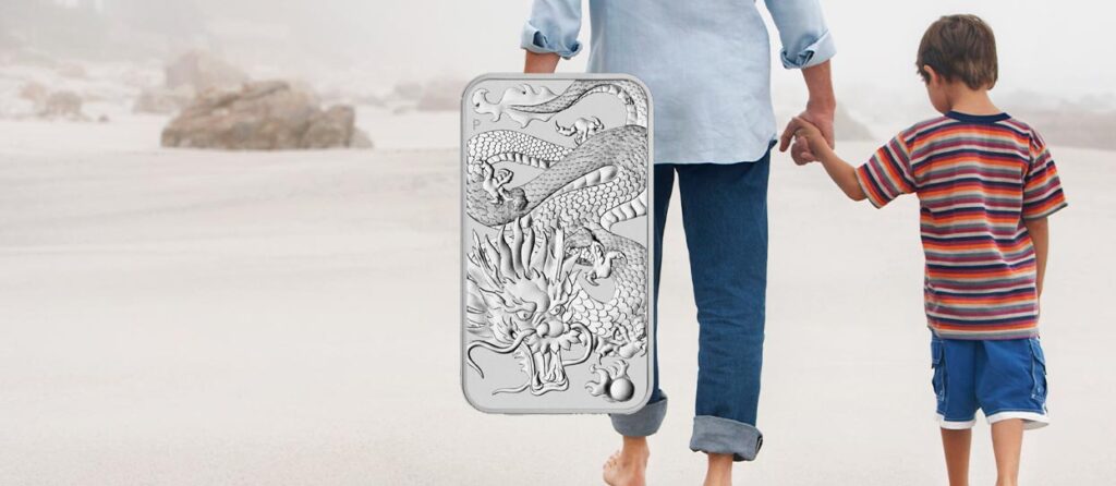 Montaje de la moneda Dragon Rectangular de plata de 1 onza con un padre y su hijo de fondo caminando sobre una playa