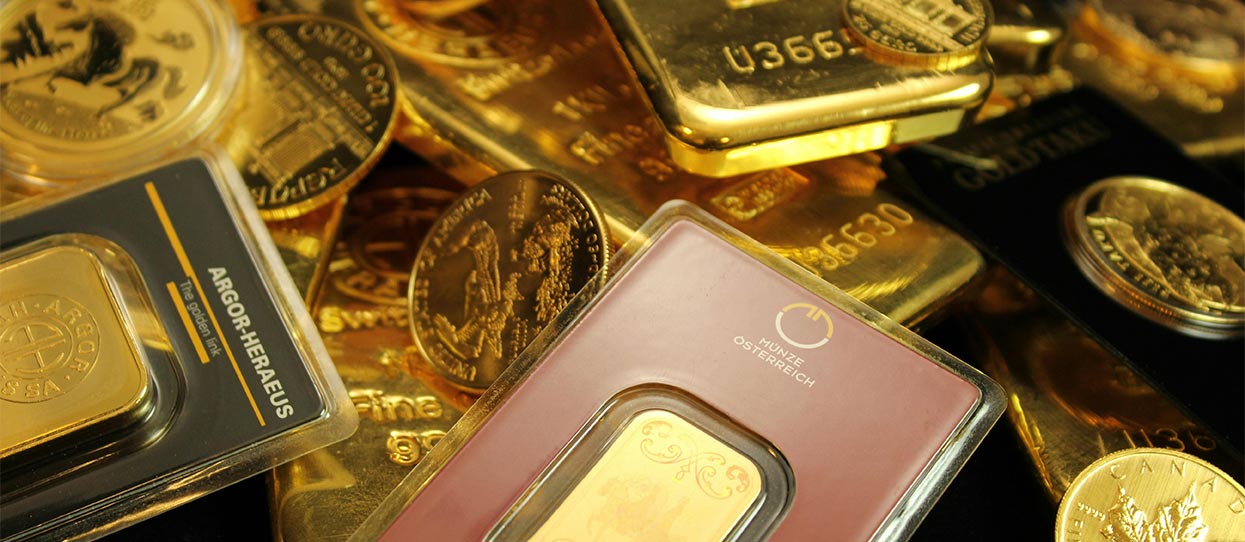 Lingotes y monedas de oro apilados uno encima del otro | Todos los impuestos que has de pagar al vender tu oro
