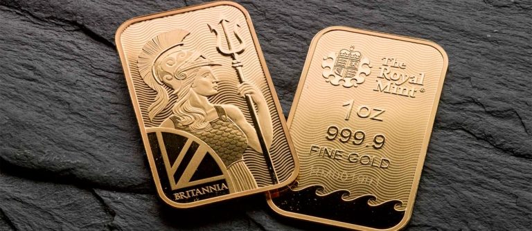 Todo lo que necesitas saber de los impuestos a la hora de comprar oro | Dos lingotes de oro de The Royal Mint sobre una mesa de mármol