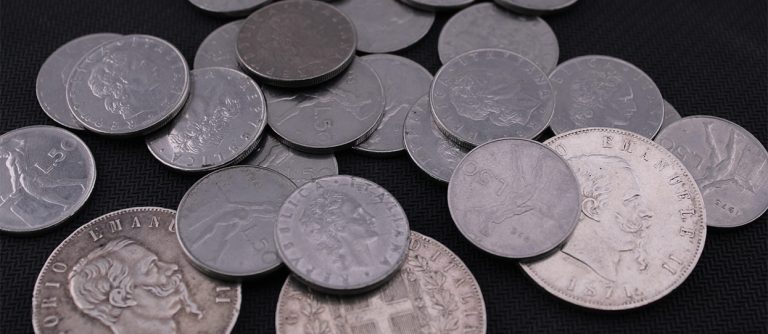 Diferentes monedas antiguas de procedencia variada, sobre un fondo oscuro