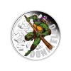 Perspectiva frontal de la cruz de la moneda de plata policromada Donatello de 1oz de 2025, que muestra a la tortuga portando su arma con un semblante serio